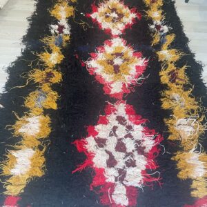 Photo d'un tapis boucherouite fond noir motifs berbère.