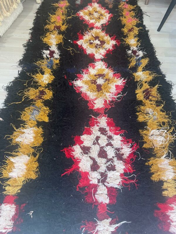 Photo d'un tapis boucherouite fond noir motifs berbère.