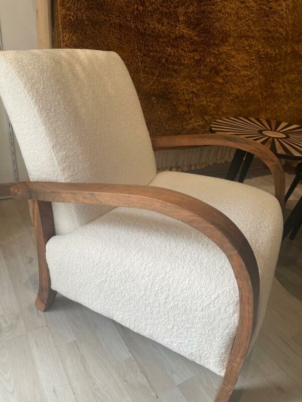 Photo d'un fauteuil en bois de noyer et tissu bouclette écru.